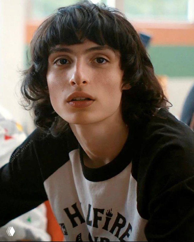 Крупный портрет молодого человека с чёлкой и выразительными глазами; кадр выглядит как продюсерский или съёмочный момент, спокойный интерьер.