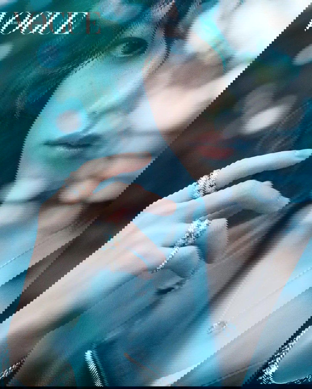 Фотосессия в стиле fashion: крупный план руки с несколькими кольцами на фоне частично раздробленного отражения, художественный боке.