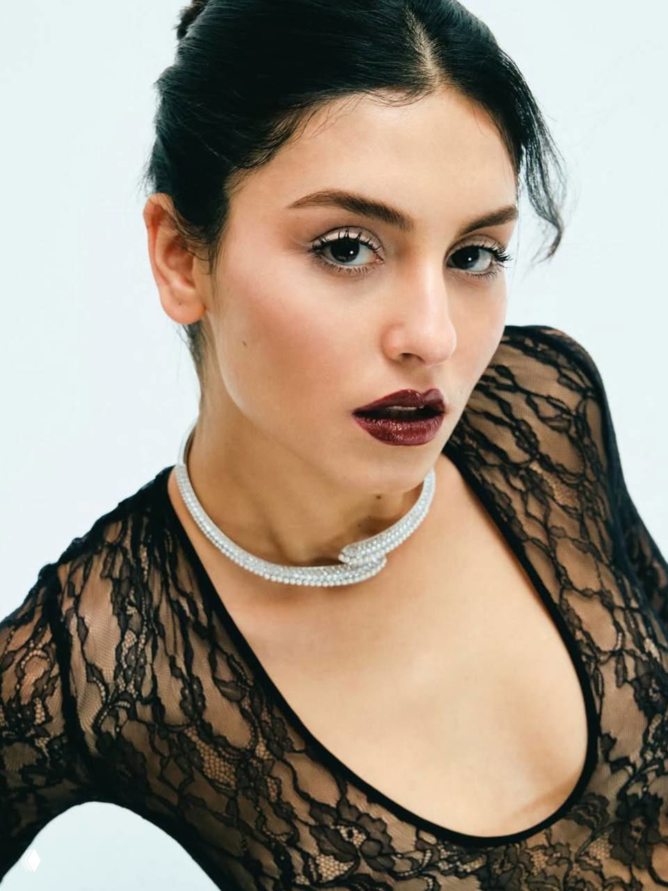 Крупный портрет Рожбин Эрден в кружевном платье и жемчужном ожерелье: светлый фон, подчёркнутый макияж