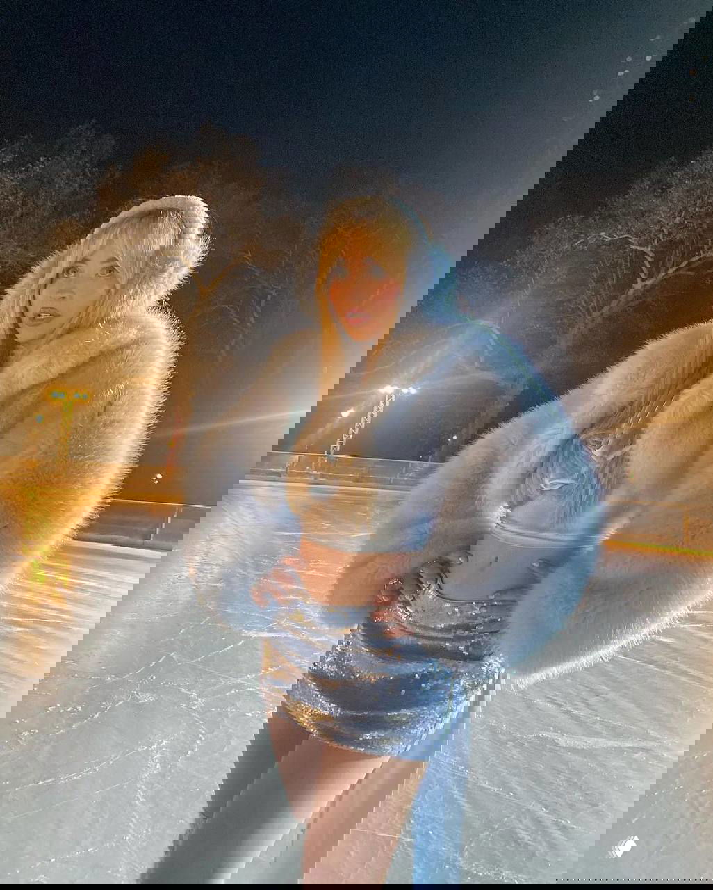 Сабрина Карпентер на катке в праздничном наряде: короткий топ, блестящая мини-юбка и пушистая голубая шубка в ночной сцене