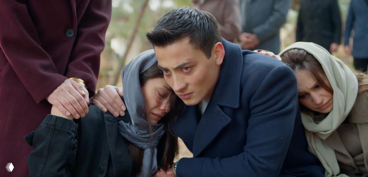 Кадр из сериала: Зеррин в трауре и другие герои у могилы, люди плачут и обнимаются — сильная сцена похорон и скорби в эпизоде.