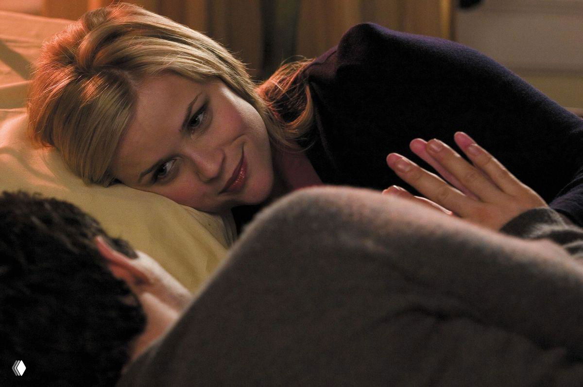 Кадр из фильма «Между небом и землей»: Элизабет (Риз Уизерспун) лежит рядом с мужчиной в постели, мягкое интимное освещение, нежный взгляд