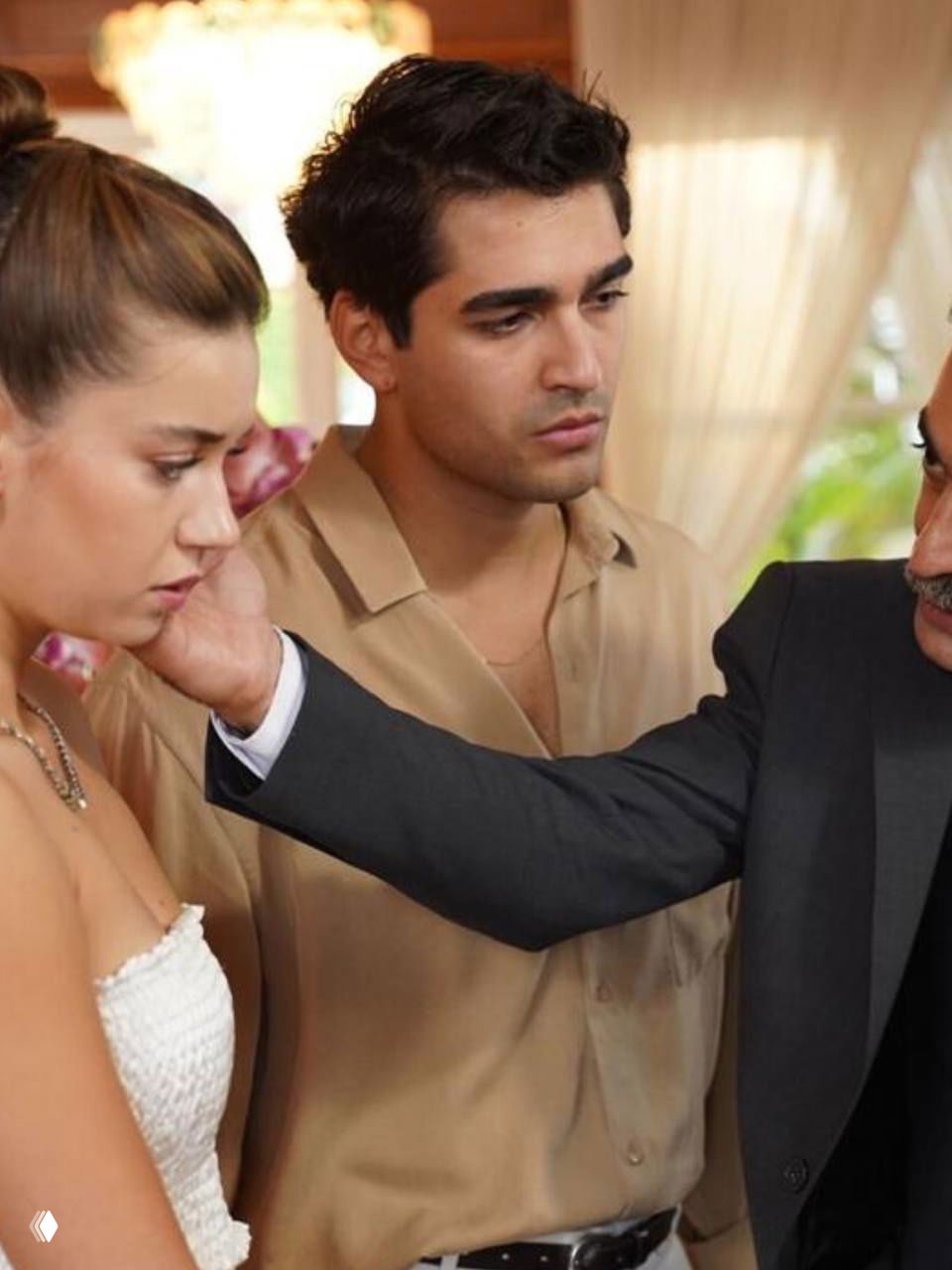 Крупный план драматической сцены из телесериала: женщина в белом платье выглядит расстроенной, мужчина рядом касается её лица в интерьере.