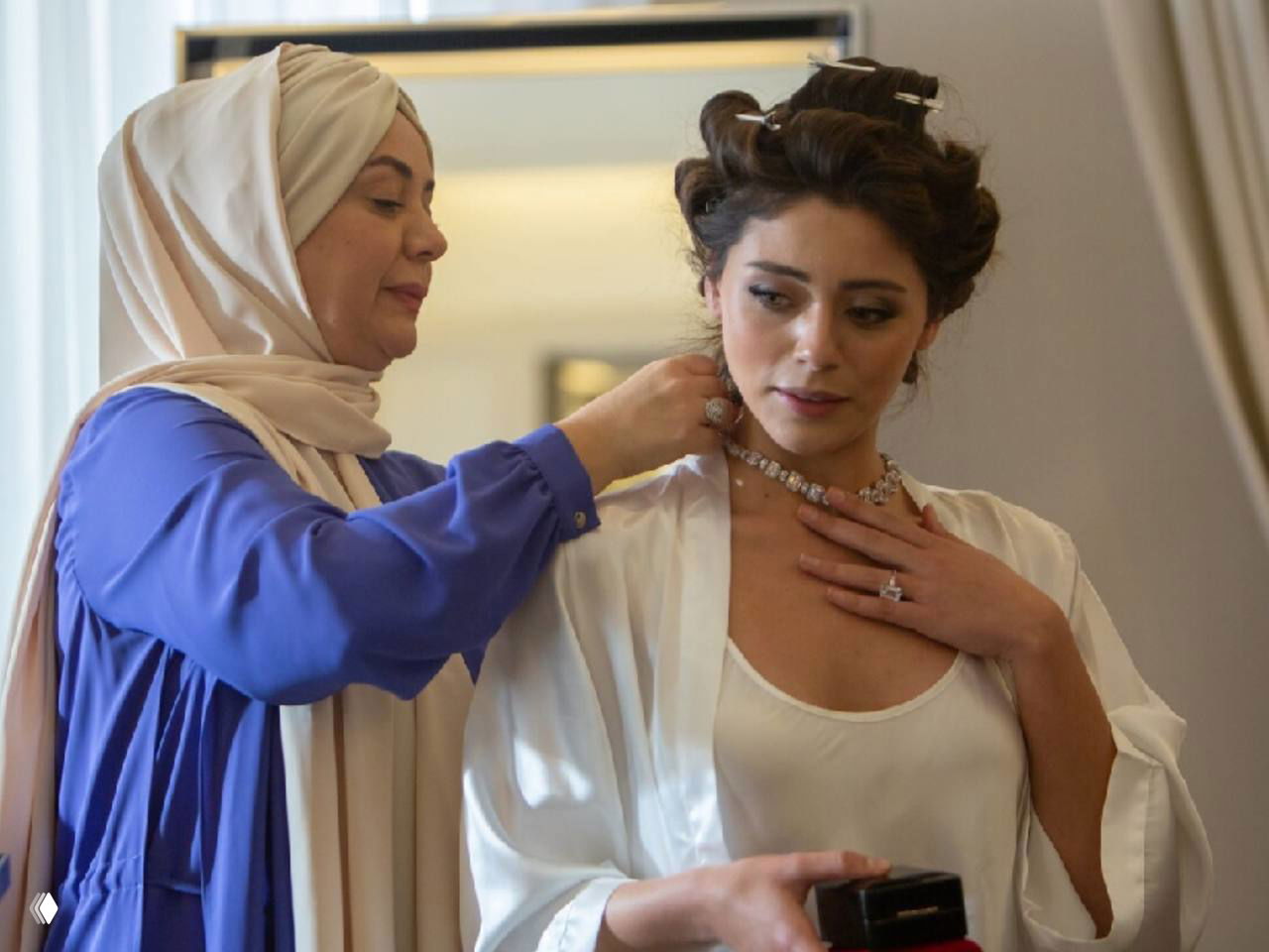Кадр со съемок сериала «Клюквенный щербет»: женщина в платке поправляет ожерелье у актрисы в халате, эмоциональная сцена