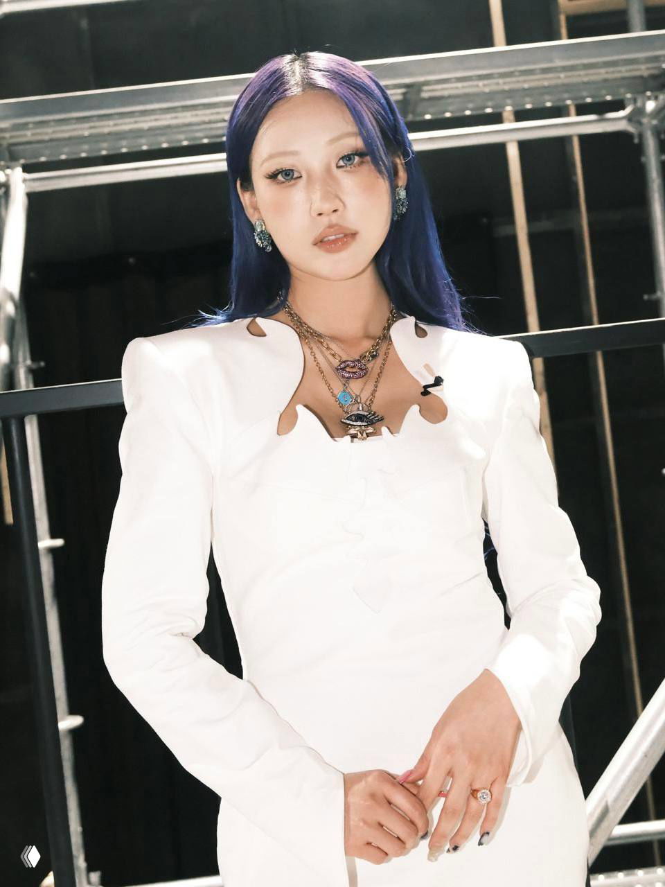 Портретная фотография селебрити в белом платье с выразительным макияжем и синими волосами — стильный образ на промо и сцене.