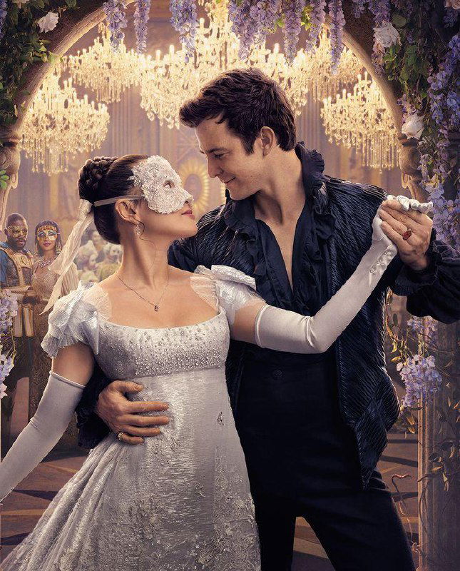 Постер/промо: Люк Томпсон и актриса Эрин Ха танцуют вместе под хрустальными люстрами — романтический кадр с маскарадной сцены.