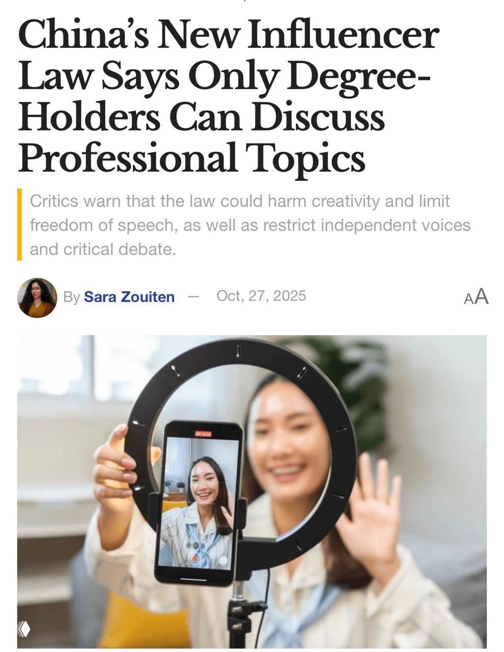 Фото блогера во время съёмки: женщина с телефоном в держателе и кольцевой лампой, ведёт прямой эфир или снимает видео в домашней обстановке.