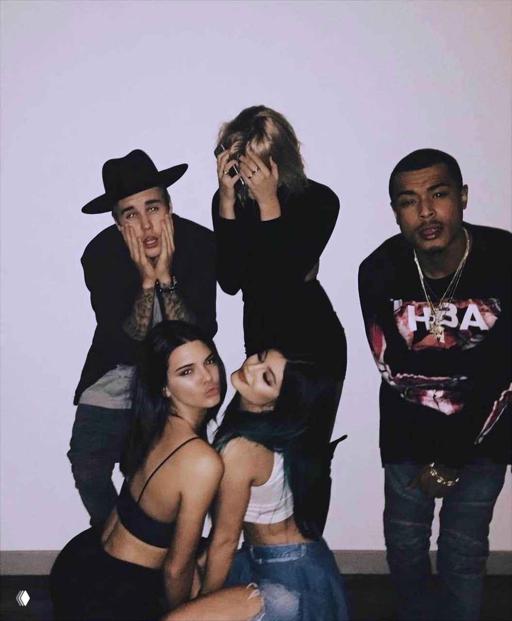 Группа друзей позирует у белой стены: близкие планы, игривые выражения лиц и сценическое позиционирование в духе домашней фотосессии 2016–2018.