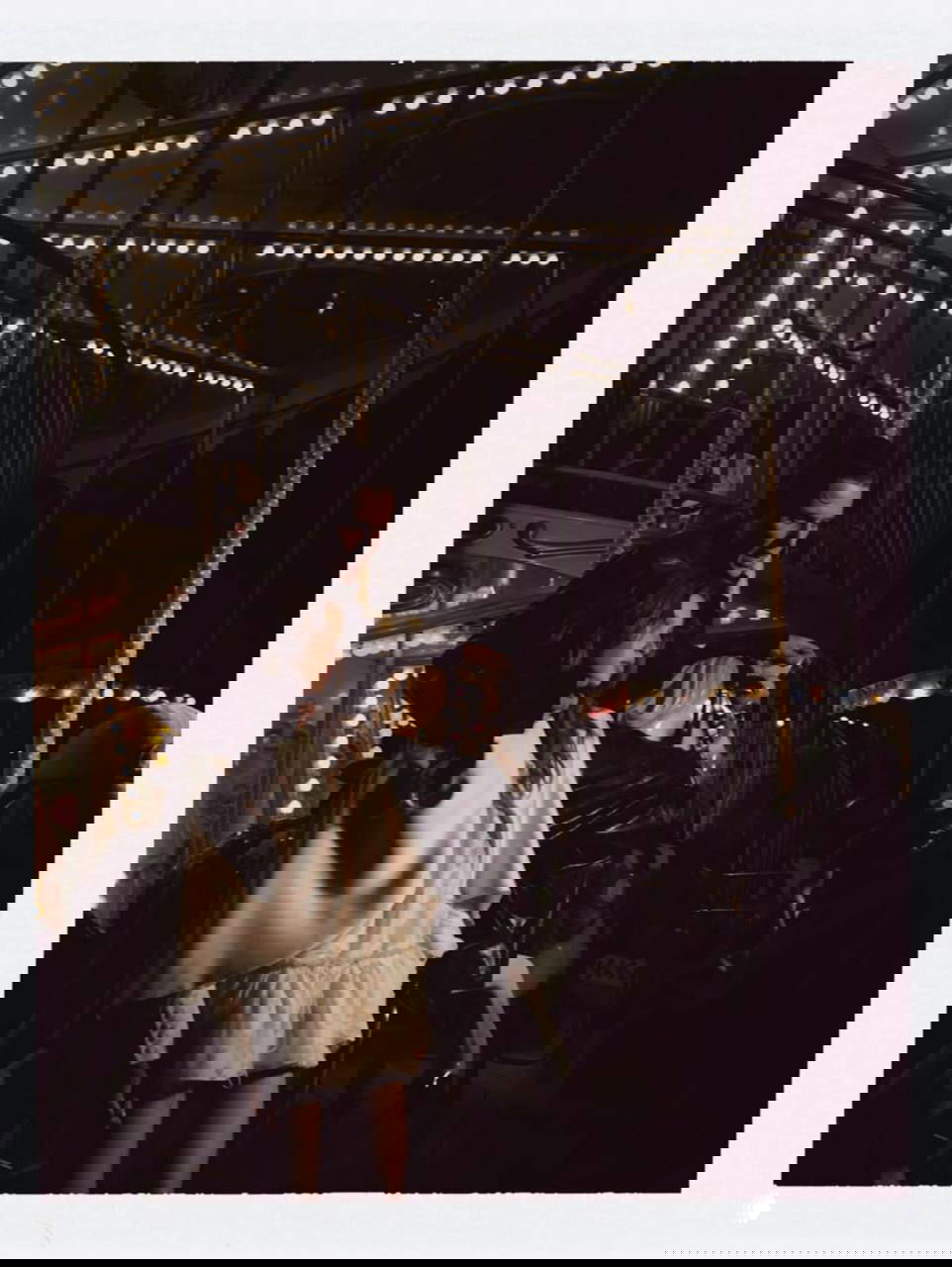 Ночная кинематографичная сцена на карусели: мужчина и девушка на аттракционе в полумраке и огнях, тёплый ретро-оттенок и атмосферное освещение.