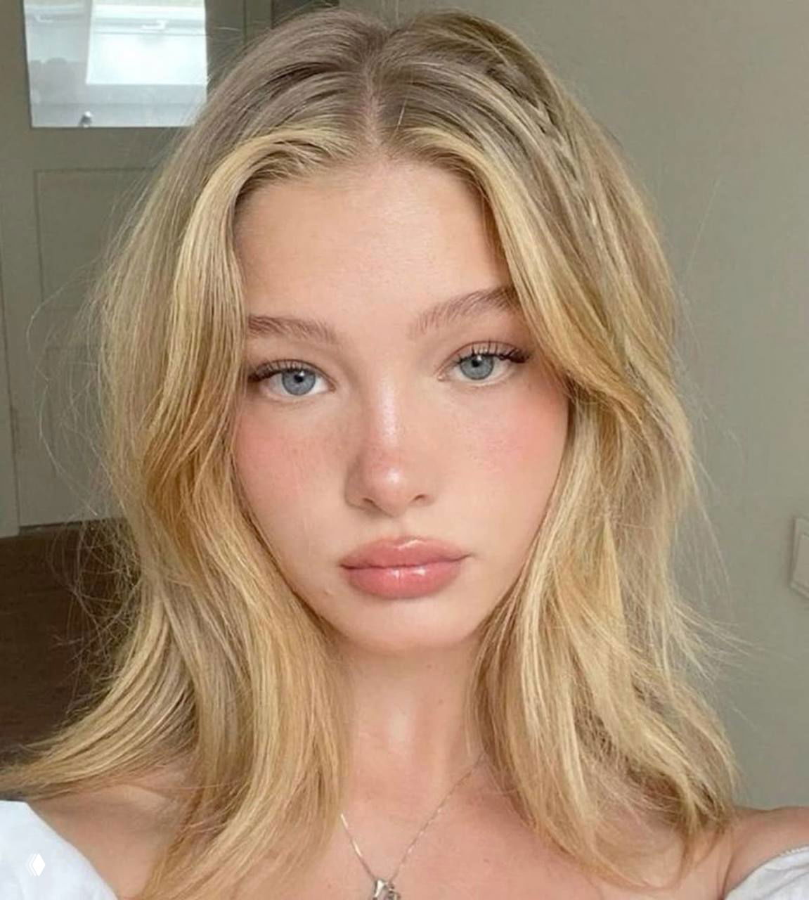 Портрет молодой блондинки со свежим естественным макияжем, розовыми румянами и мягким светом, подчёркивающим текстуру кожи и натуральный образ.