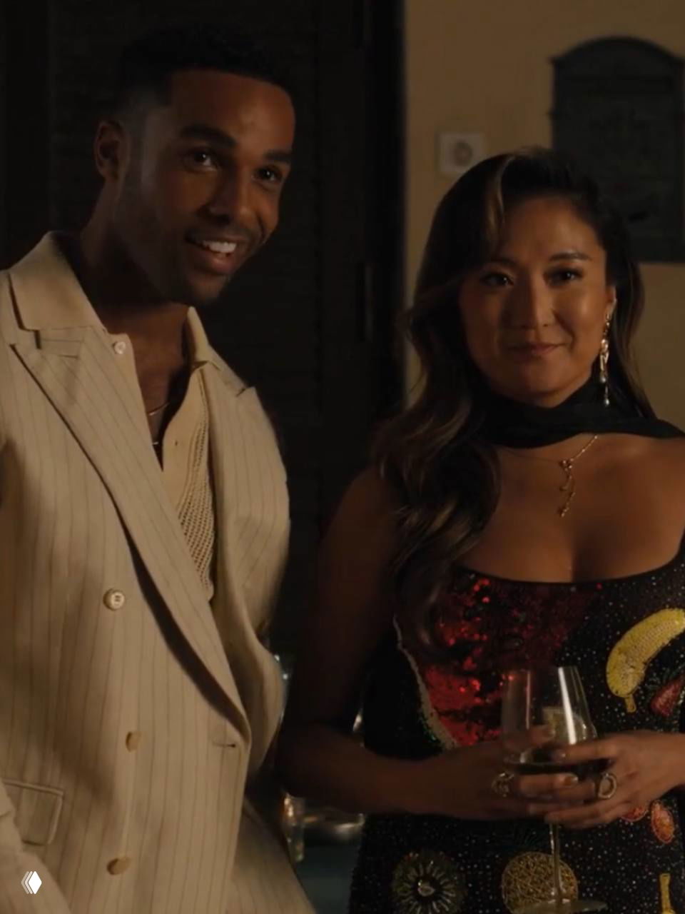 Минди и Альфи в вечернем освещении улыбаются гостям — кадр, подчёркивающий их связь и начало любовной линии.