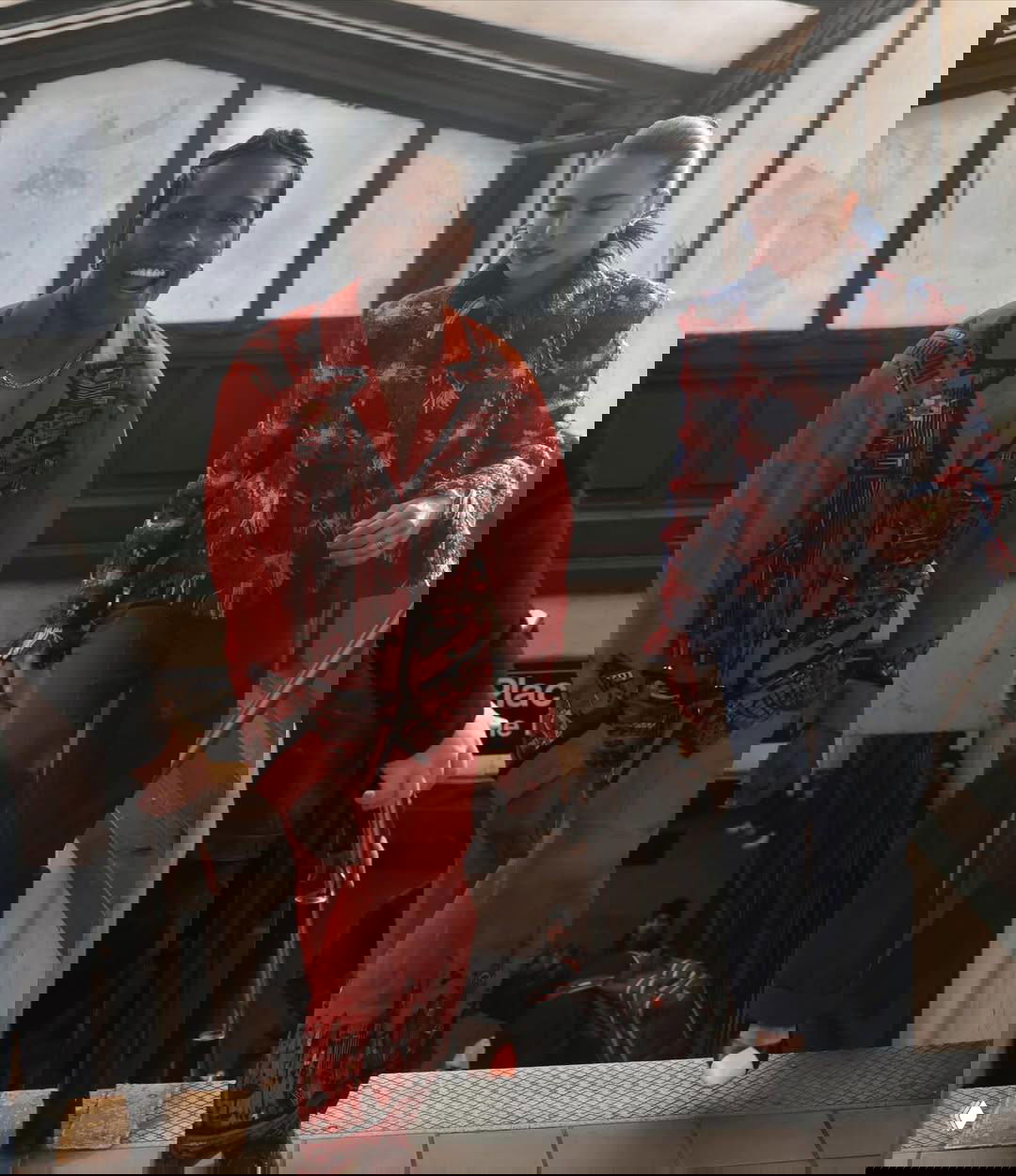 Двое в модной одежде спускаются по лестнице метро — мужчина улыбается, сцена выглядит как часть рекламной съёмки бренда.