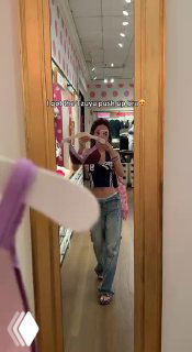 Зеркальное селфи в магазине: пример примерки белья и образа в стиле K-pop; видно продавец/примерочная обстановка и предметы в интерьере магазина.