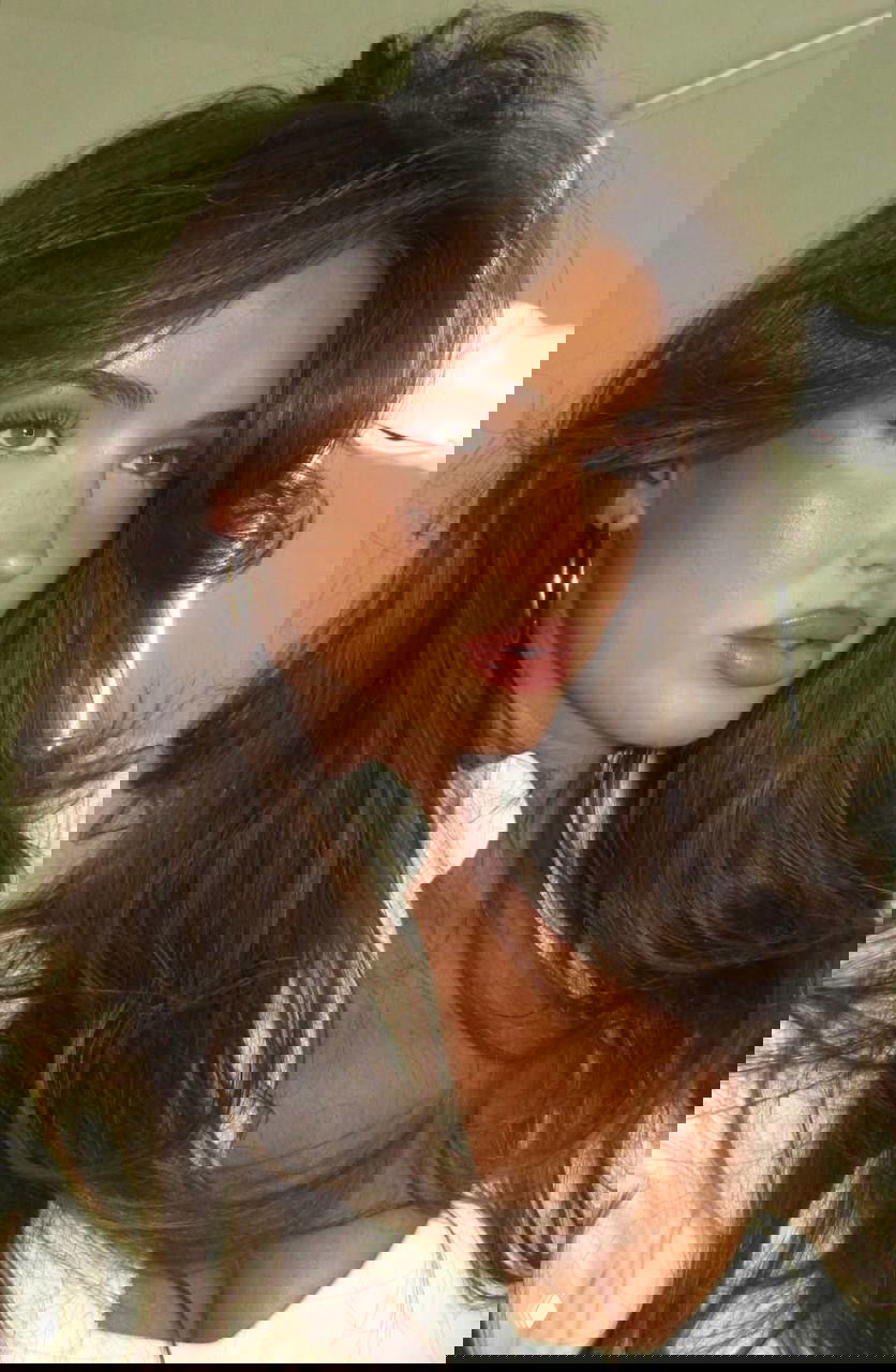 Крупный портрет женщины с объёмной стрижкой и бронзовым тоном кожи; макияж подчёркивает контуры и естественный блеск губ.