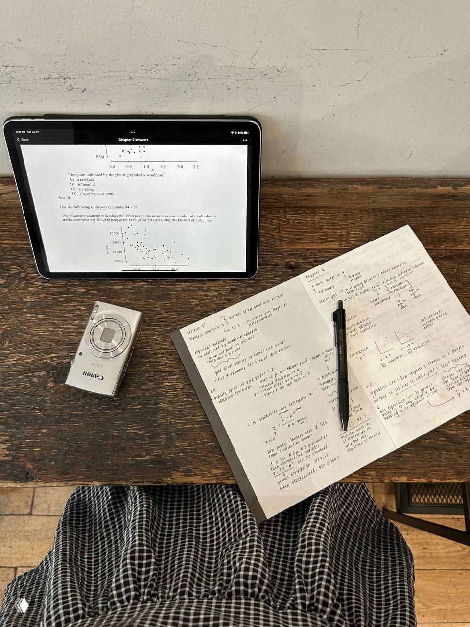 Рабочая композиция на деревянном столе: планшет с текстом, раскрытая тетрадь с заметками и ручка — атмосфера организованной подготовки.