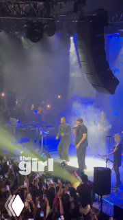 Эмре Алтуг на сцене московского сольника: певец и бэнд в свете прожекторов, зрители с телефонами снимают момент