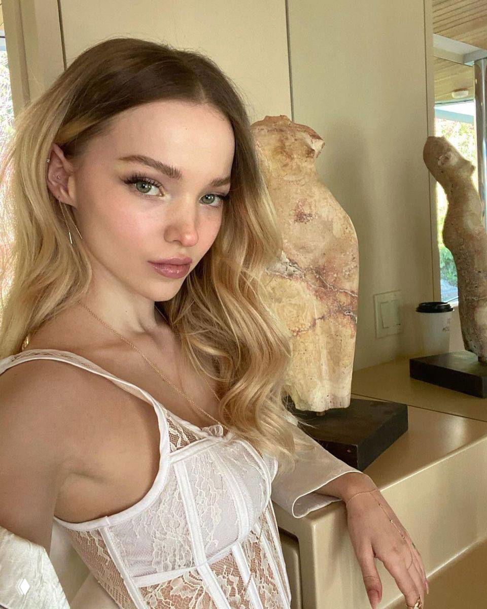 Портрет женщины в белом кружевном топе с мягким пастельным макияжем, тёплое освещение и интерьер на заднем плане