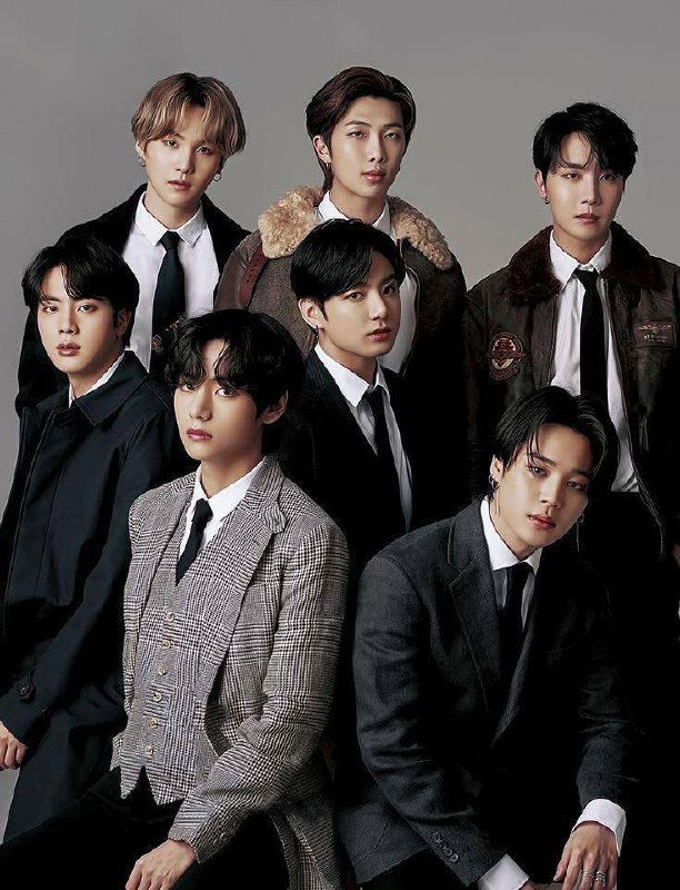 Официальная фотосессия BTS: семеро участников в деловых костюмах на нейтральном фоне, формальный портрет для промо‑материалов