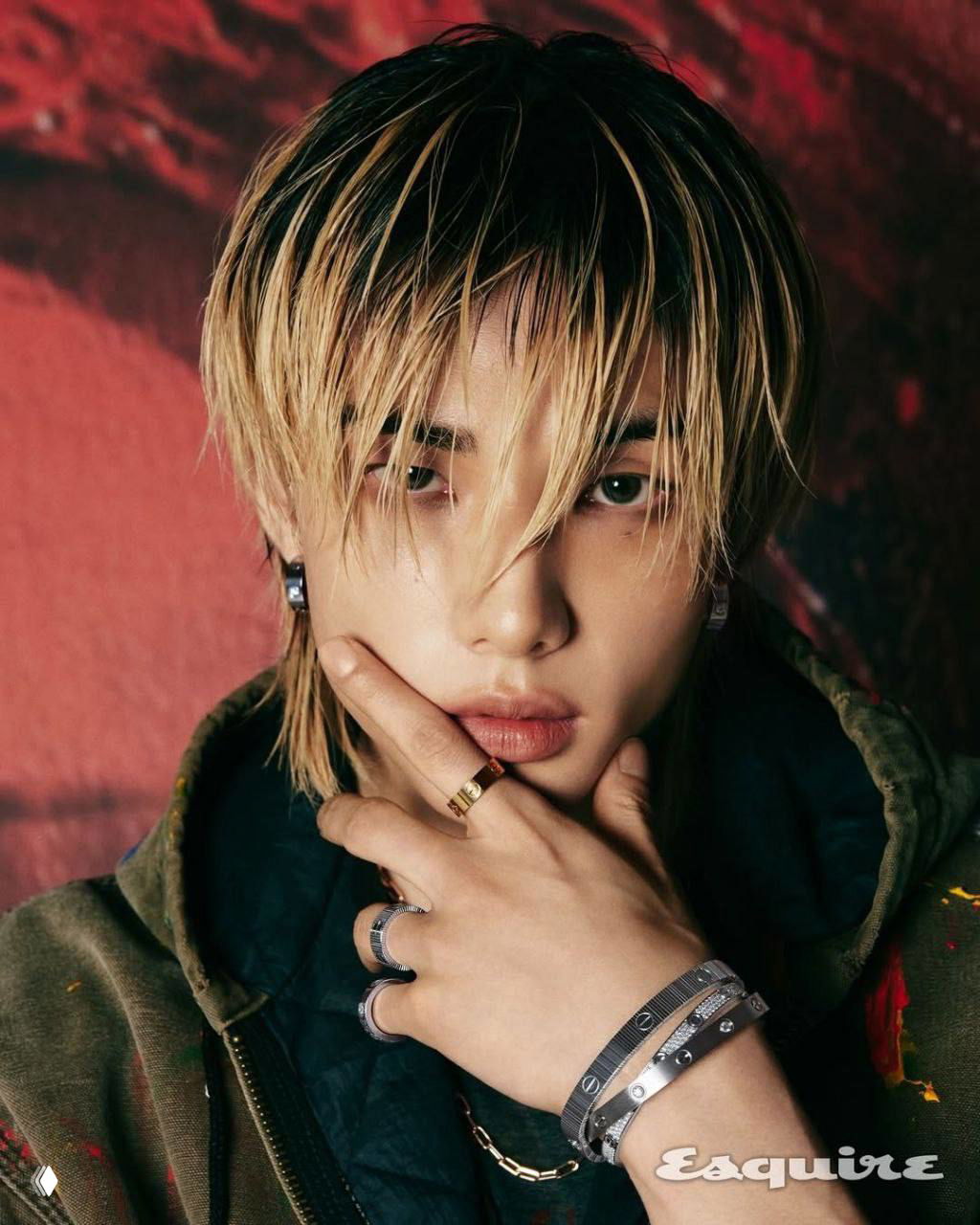 Крупный студийный портрет молодого айдола с влажной причёской и кольцами на пальцах, интенсивный взгляд и текстурный фон — стилистика модной съёмки.