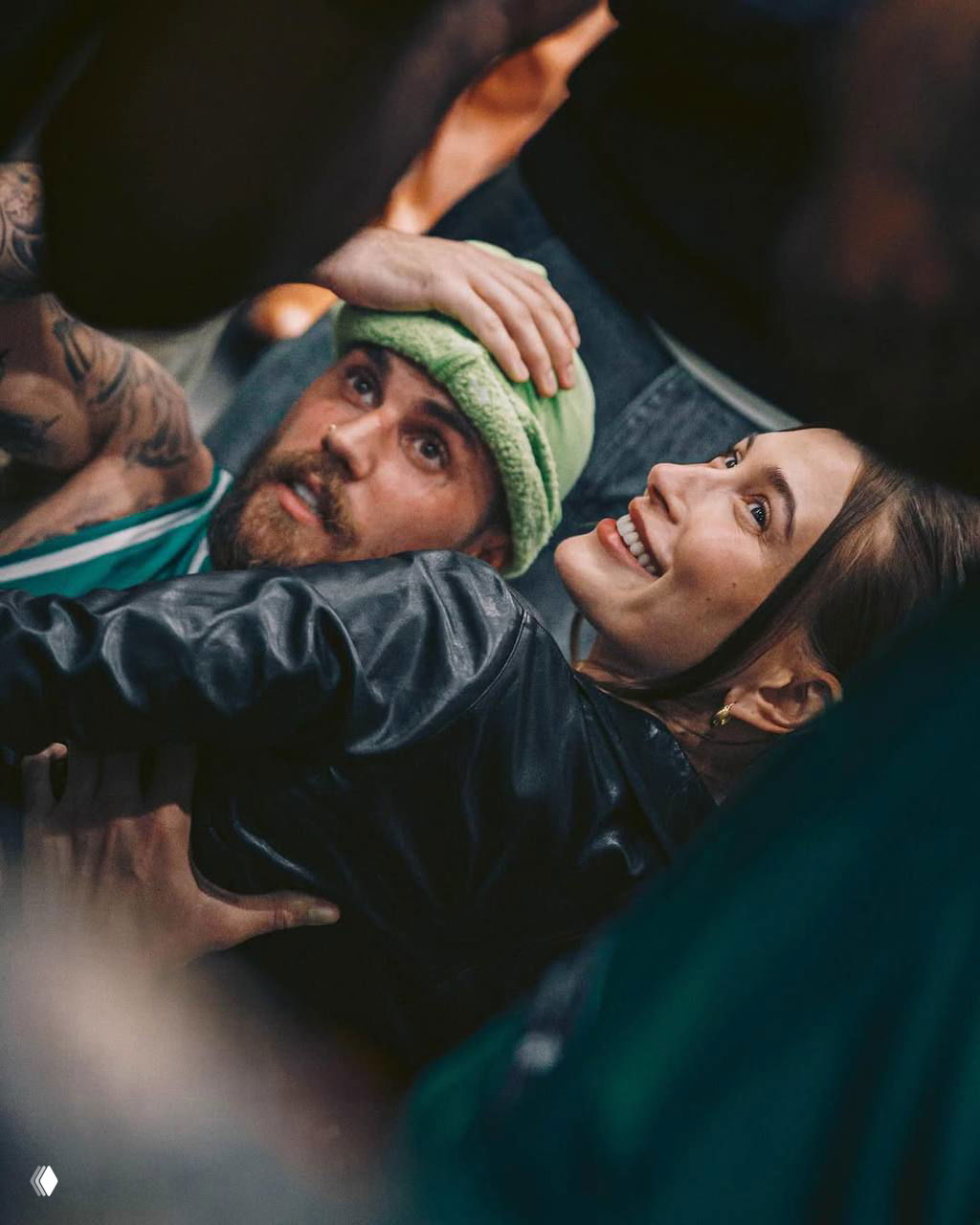 Крупный план: Хейли Бибер улыбается в толпе рядом с Джастином Бибером в шапке — момент на публичном мероприятии, тёплая и эмоциональная сцена.