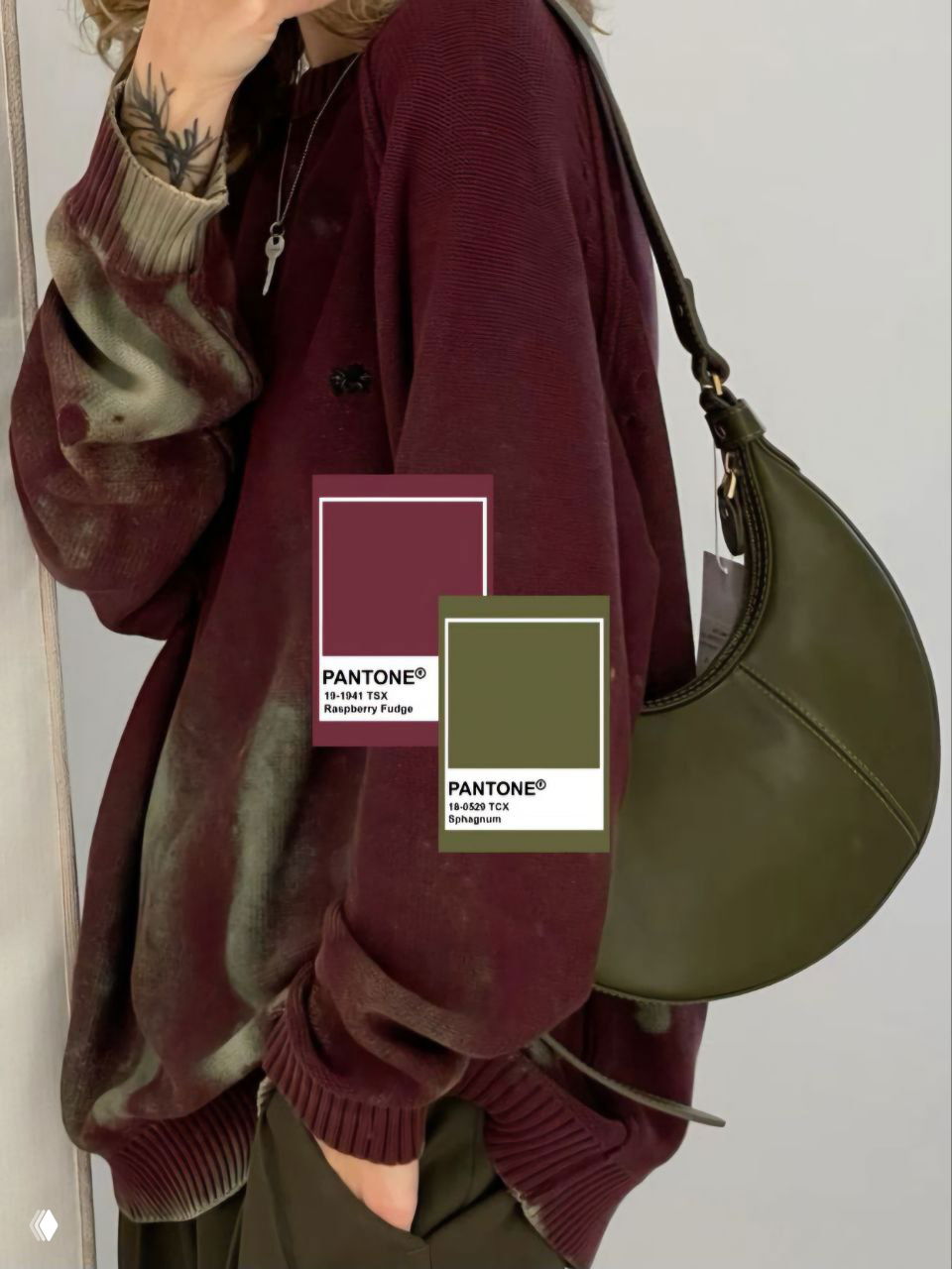 Крупный план бордового свитшота на фоне зелёной сумки и карточек Pantone с образцами бордового и оливкового — наглядная палитра для сочетания цветов.