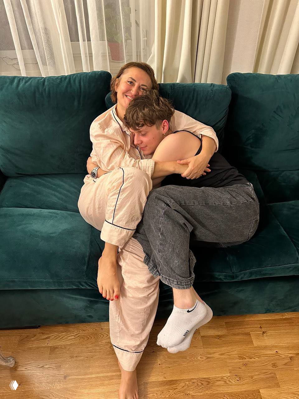 Тёплый семейный кадр: Ваня Дмитриенко прижимается к маме на зелёном диване, домашняя обстановка и эмоциональная сцена уюта.