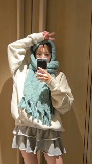 Зеркальное селфи: человек в светлом худи и тёплом мятном шарфе, держит телефон для фото в комнате; видно одежду и отражение, зимняя атмосфера.