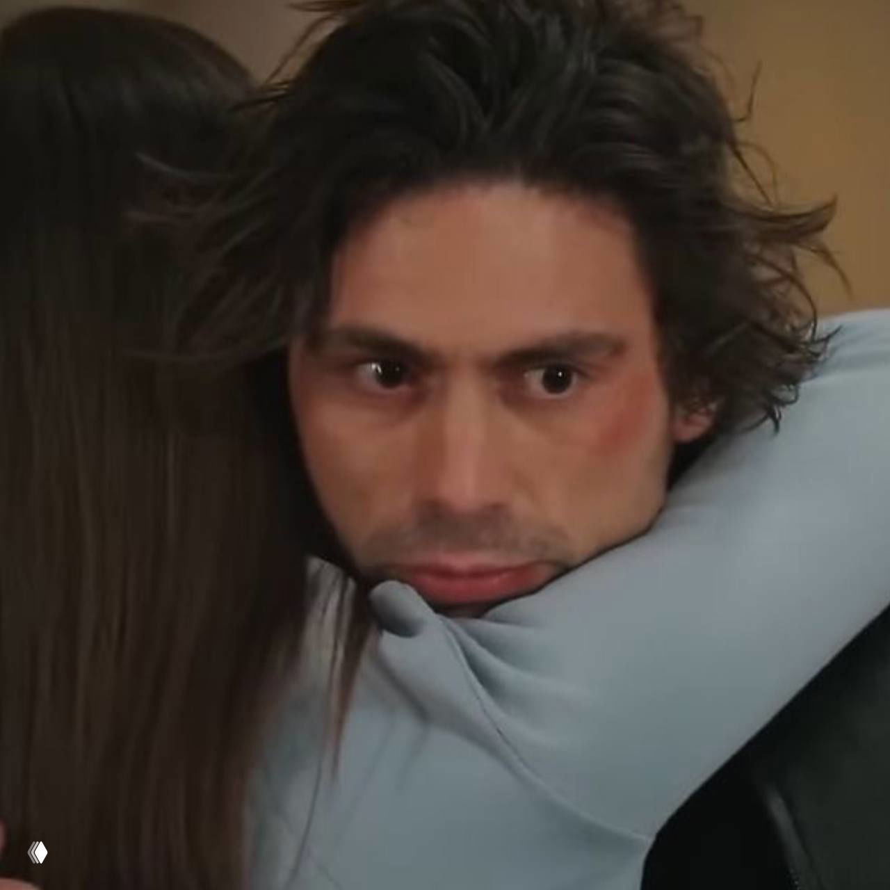 Крупный план мужчины в объятиях женщины, на лице героя читается беспокойство и тревога, сцена передаёт эмоциональное напряжение.