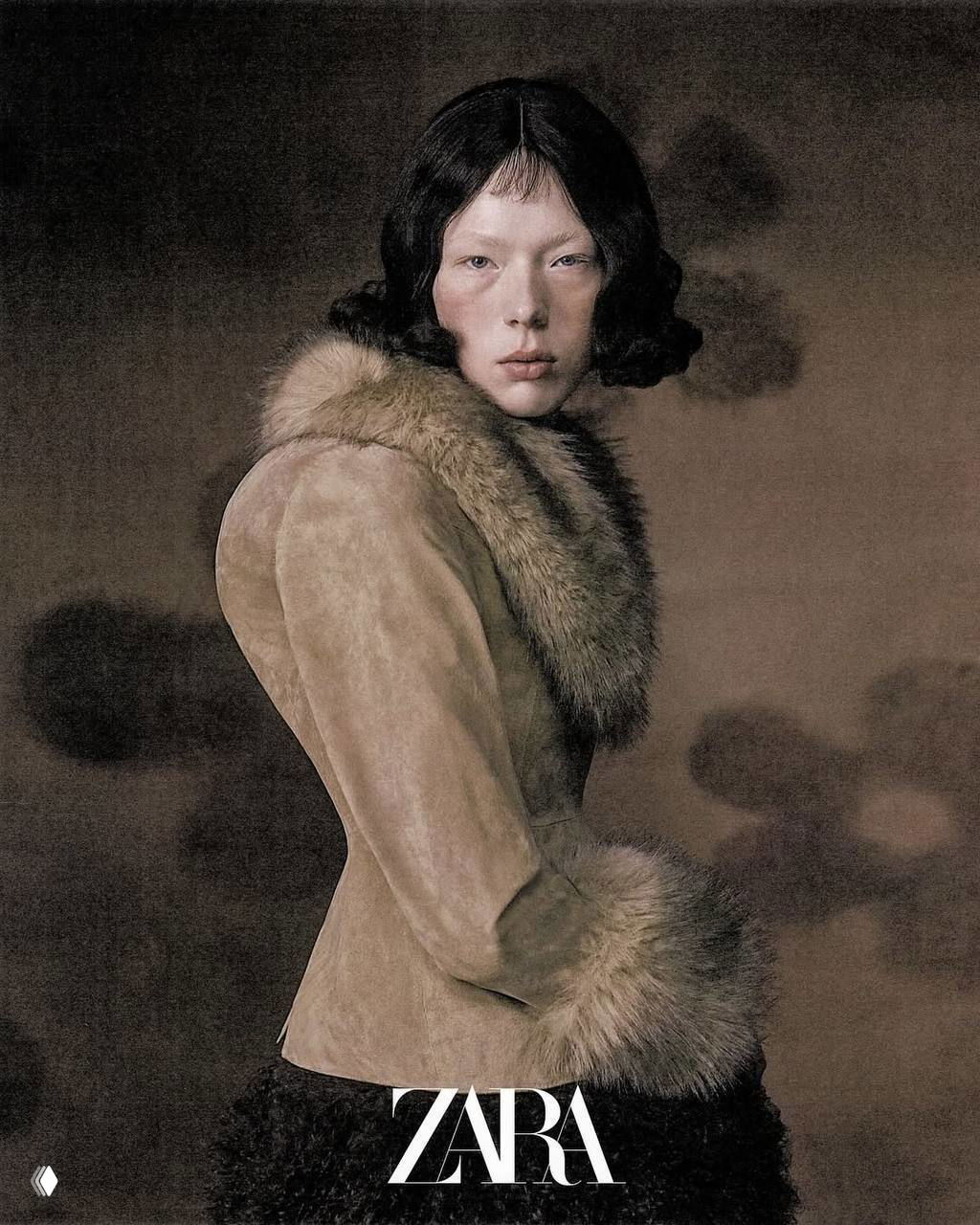 Портретная фотография из кампейна Zara: близкий план модели в пальто с меховой отделкой, приглушённые тона и туманная текстура фона создают зловещий эффект.