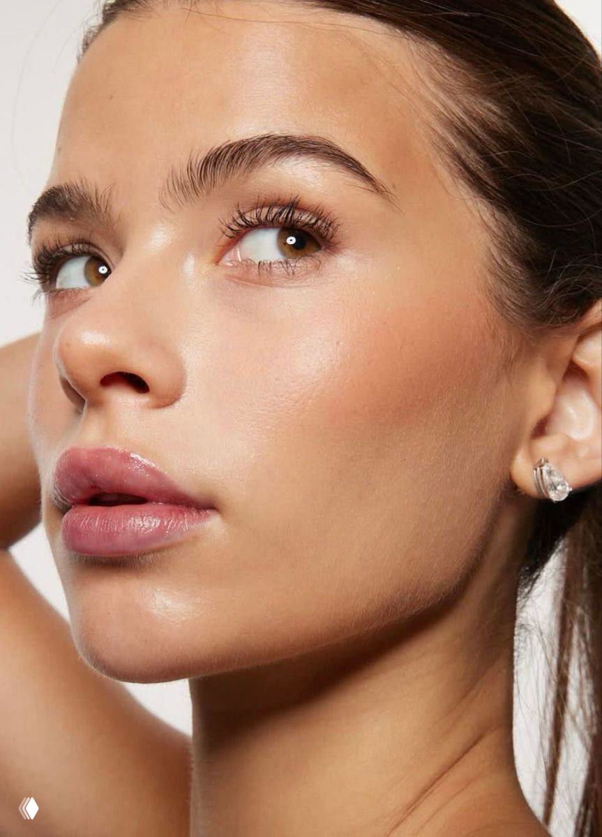 Макрокадр чистой сияющей кожи с естественными бровями и матовым контуром — акцент на здоровом glow и минималистичном макияже.
