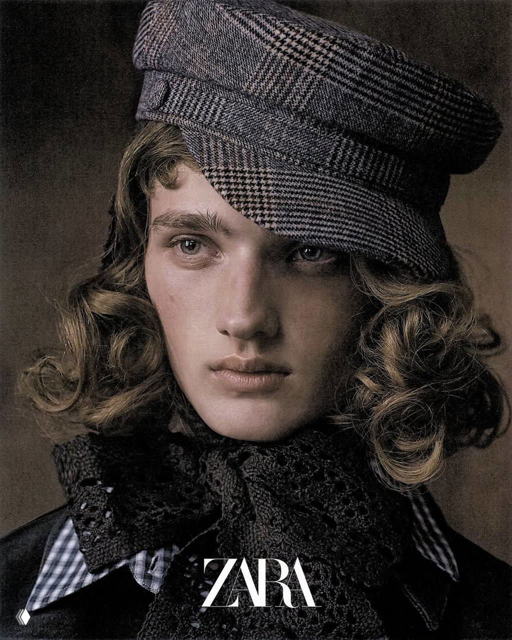 Крупный план лица модели в кепке и кружевном воротнике из кампейна Zara: натуральная мимика, текстуры ткани и фирменный минимализм логотипа ZARA.