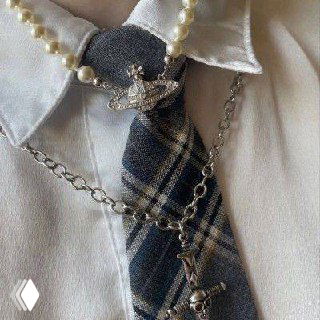 Деталь воротника, галстука и украшений в клетчатой гамме — комбинация цепочек и жемчуга для создания эстетики Фрэнки из Monster High.