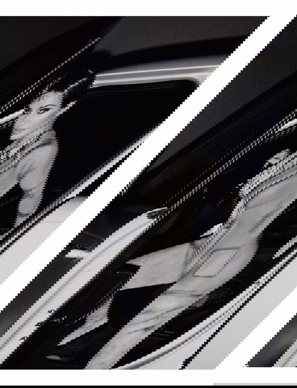 Чёрно-белая редакционная фотография женщины в стильном образе, выходящей из автомобиля — минималистичная и эстетичная съёмка в студийной стилистике.