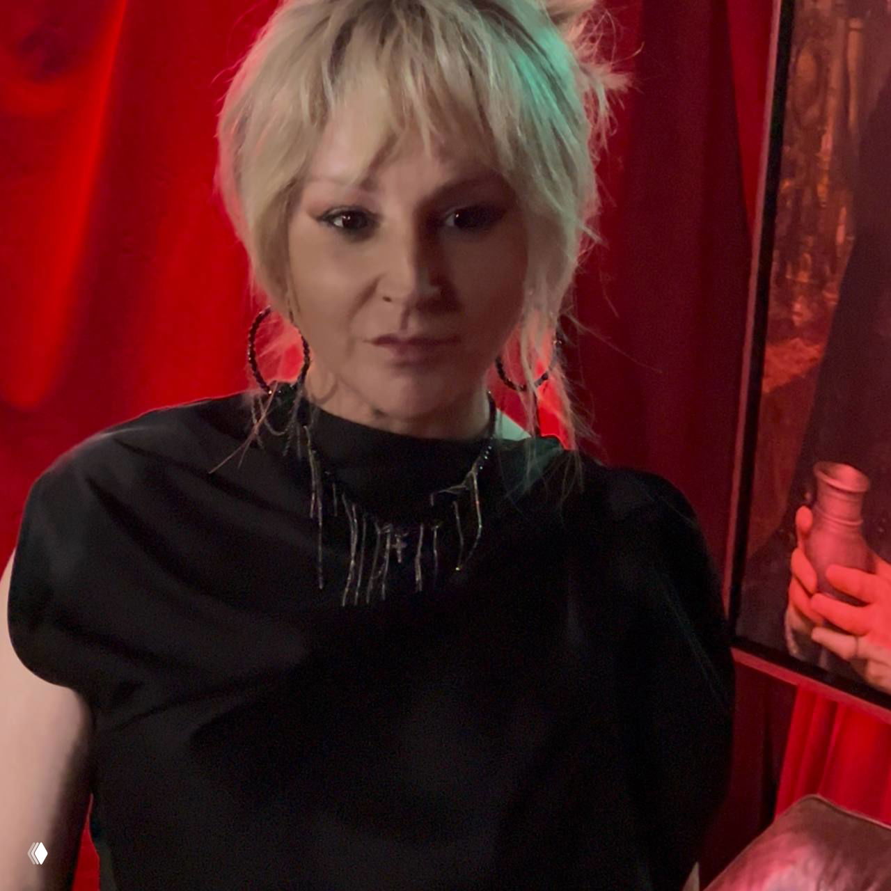 Портретная фотография женщины в вечернем образе на красном фоне презентации: атмосфера клуба с насыщенным светом и декором.