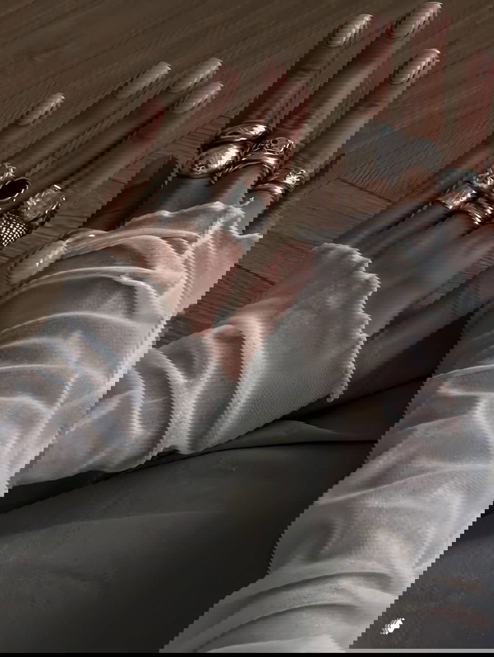 Руки с короткими овальными ногтями в нюдовом оттенке и несколькими массивными серебряными кольцами; атмосферный кадр.