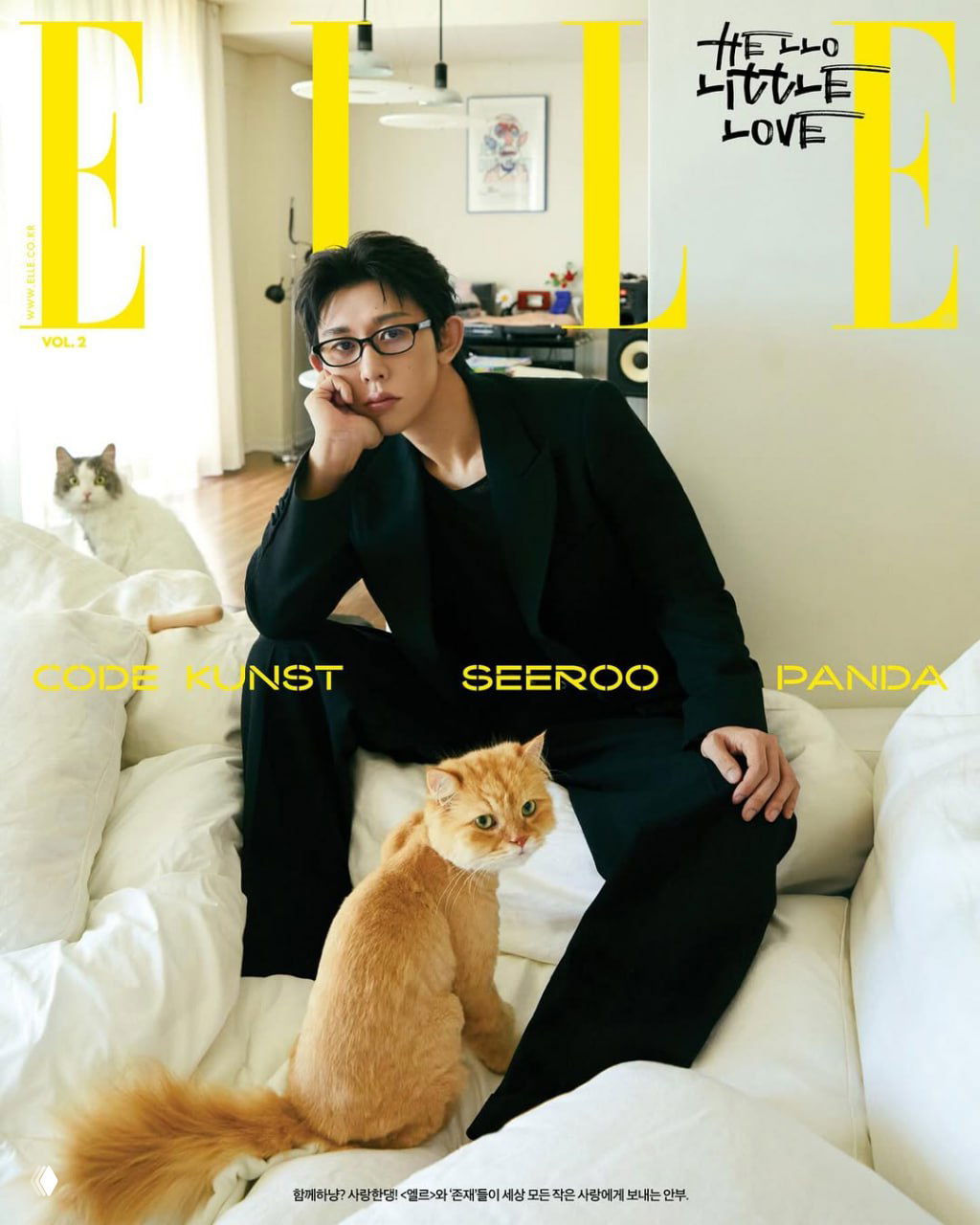 Обложка ELLE Korea: мужчина в очках сидит на кровати с двумя котами вокруг; уютный интерьер и спокойная палитра снимка.