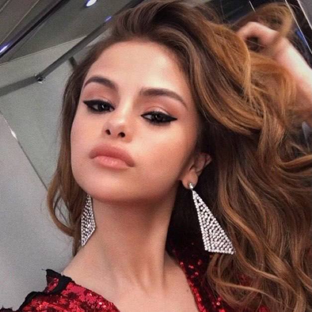 Крупный гламурный портрет женщины с вечерним макияжем и крупными блестящими серьгами, строгий взгляд и праздничный образ.