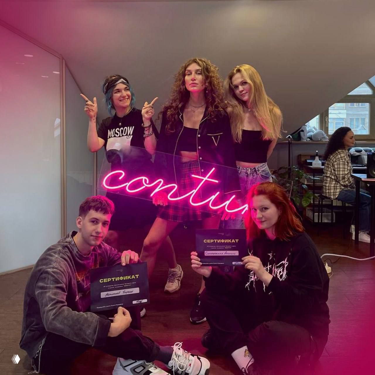 Групповая фотография выпускников мастер-класса с сертификатами на фоне неоновой вывески студии Contur — итоговое фото после обучения.