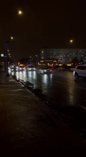 Ночной вид Садового кольца: машины в движении по мокрой дороге, городской фон, отражения огней на асфальте и тёмное небо.