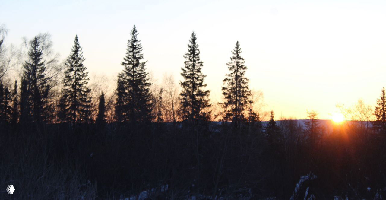 Замерзшее озеро с небольшими фигурами людей вдалеке, туманная даль и холмы под небом — момент с походной прогулки по льду Зюраткуля.