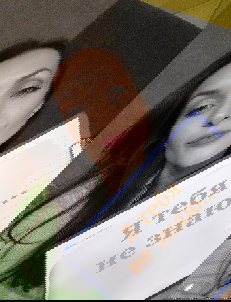 Селфи женщины в светло-зелёной рубашке, держащей папку с крупной надписью «Я тебя не знаю...», задумчивый взгляд.