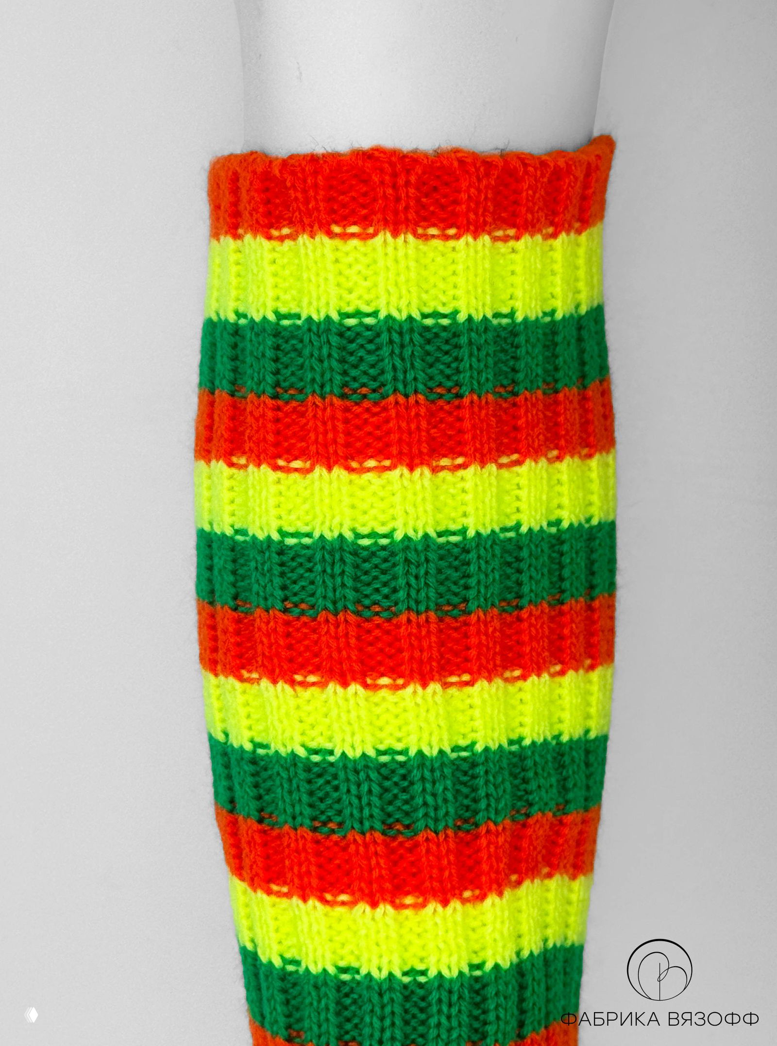 Неоновая полосатая гама гетр в жёлто‑зелёно‑оранжевых тонах, съёмка крупным планом показывает фактуру и плотность вязки на манекене.