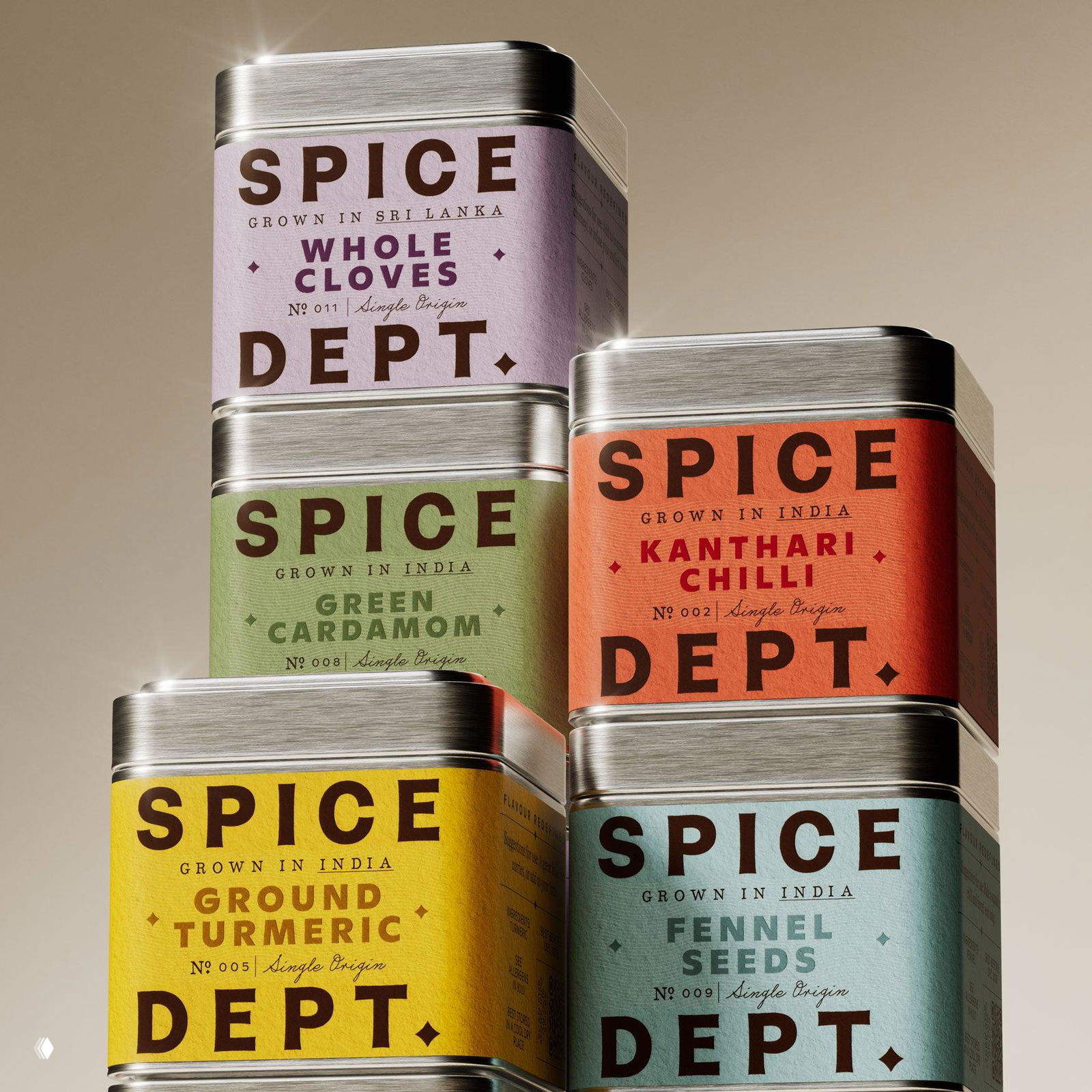 Крупный план стопки металлических коробочек специй Spice Dept с пастельными этикетками, видна текстура бумаги и металлические крышки упаковки.