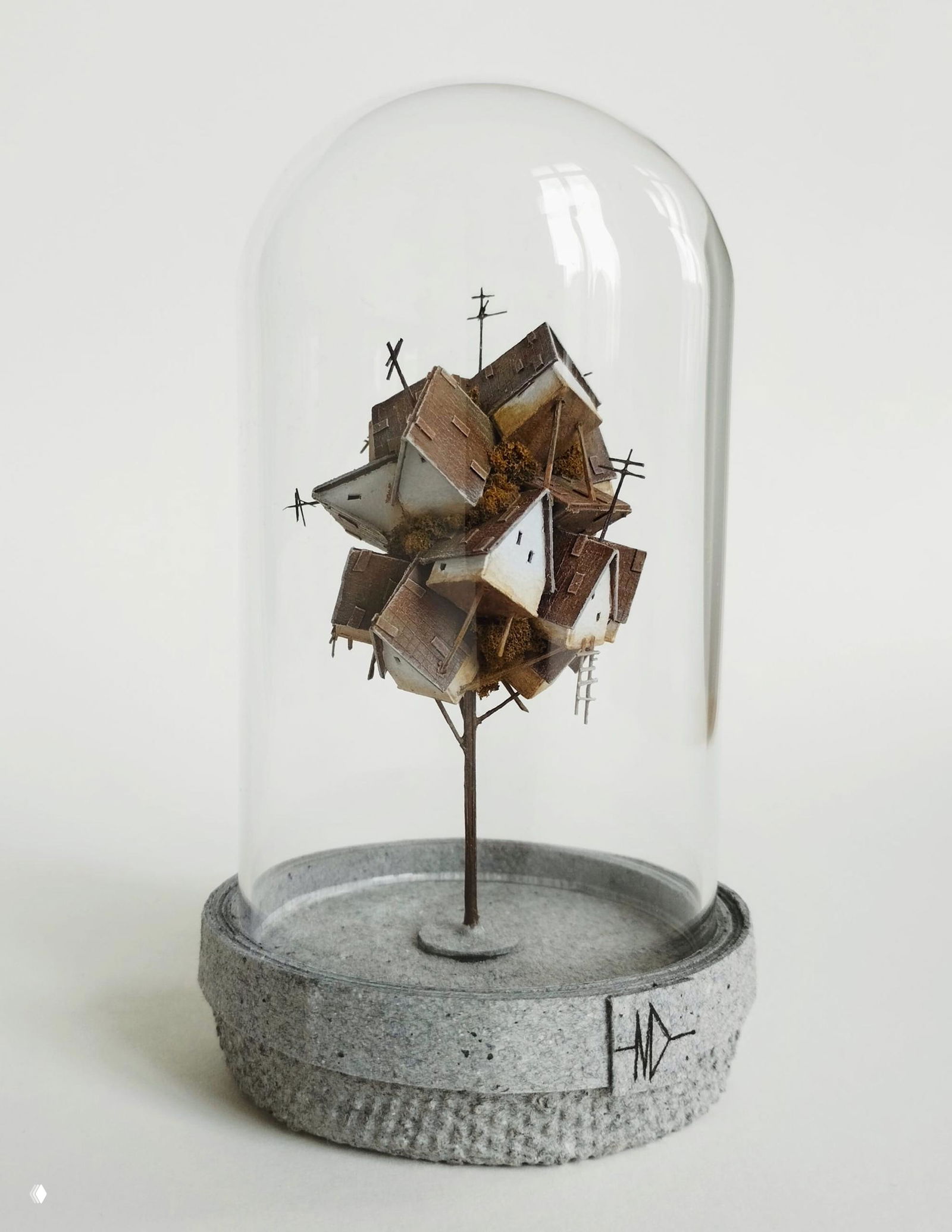 Очень тонкая вертикальная башня из миниатюрных белых домиков, удерживаемая между пальцами для демонстрации масштаба и хрупкости конструкции.