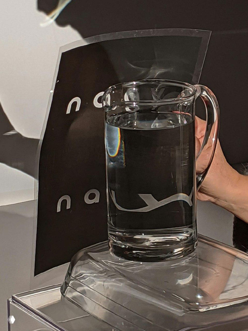 Стопка печатных материалов и размытые оттиски логотипа Moholy‑Nagy на бумаге, презентация фирменной графики и печати.