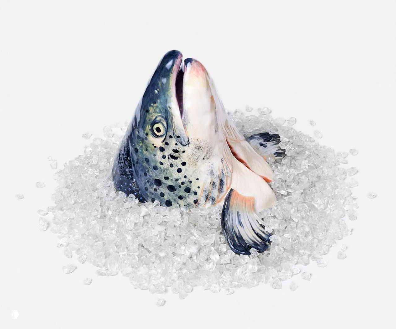 Керамическая голова рыбы, частично погружённая в имитацию льда — реалистичная скульптурная работа с детализированной чешуёй и глазами.