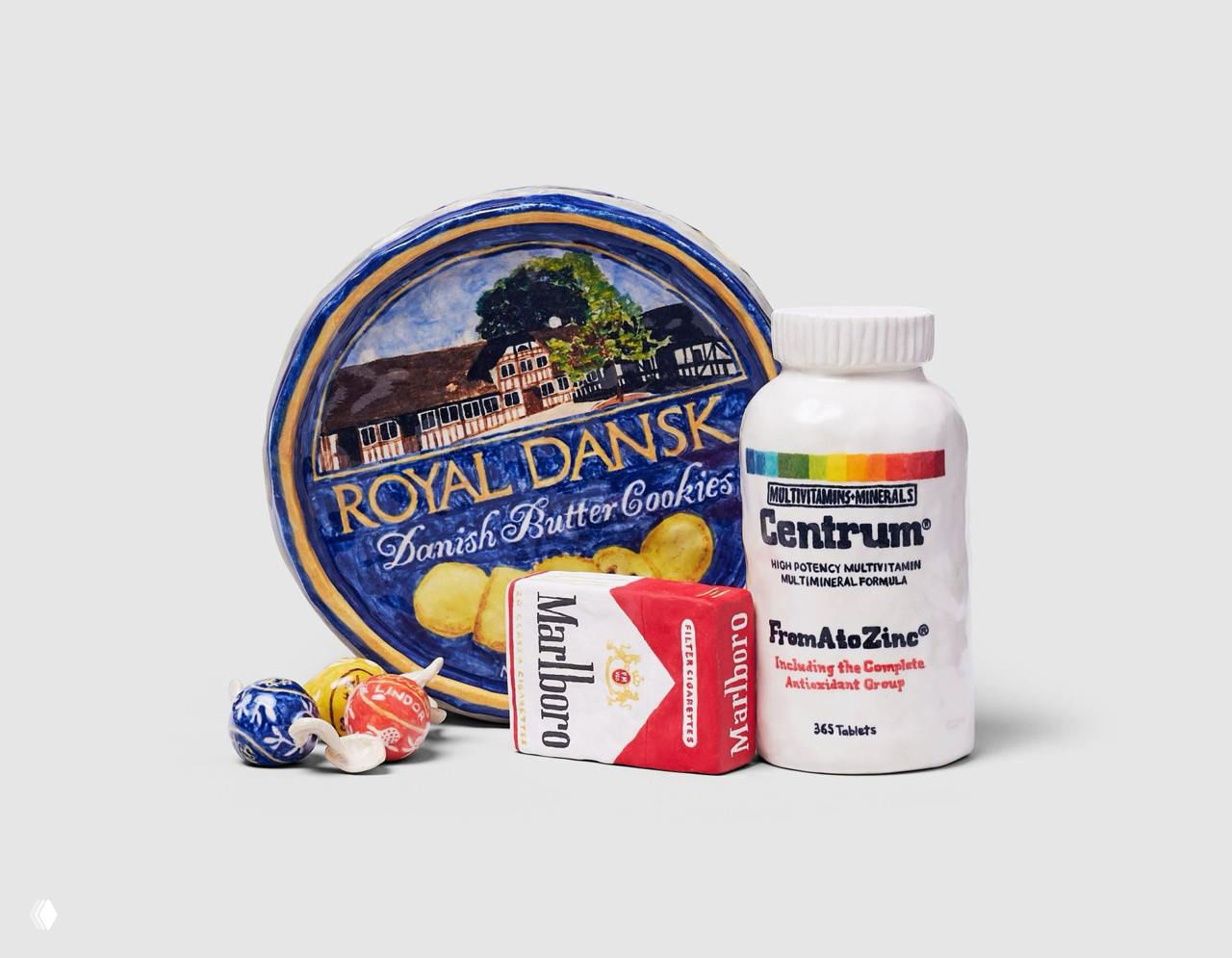 Набор керамических предметов: банка печенья Royal Dansk, пачка Marlboro и банка витаминов Centrum — фарфоровая имитация знакомых упаковок.