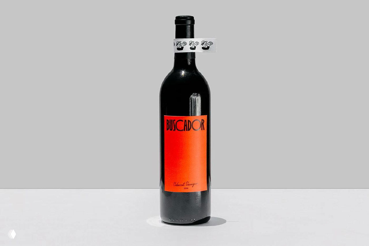 Минималистичная съемка бутылки с вертикальным оранжевым ярлыком Legal Wines на нейтральном фоне: композиция подчёркивает форму бутылки и графический ярлык.