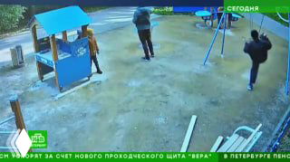 Кадр с камеры видеонаблюдения детской площадки: несколько людей у горки и качелей, зафиксирован конфликт/хулиганство, вид с высоты, уличная сцена.
