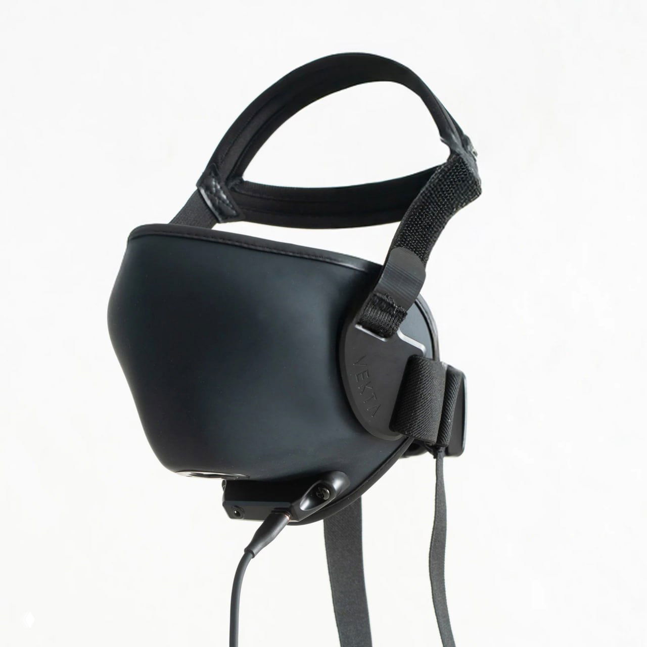 Крупный план чёрной шумоподавляющей маски Vekta на светлом фоне — видны корпус, боковые крепления и разъём для кабеля.